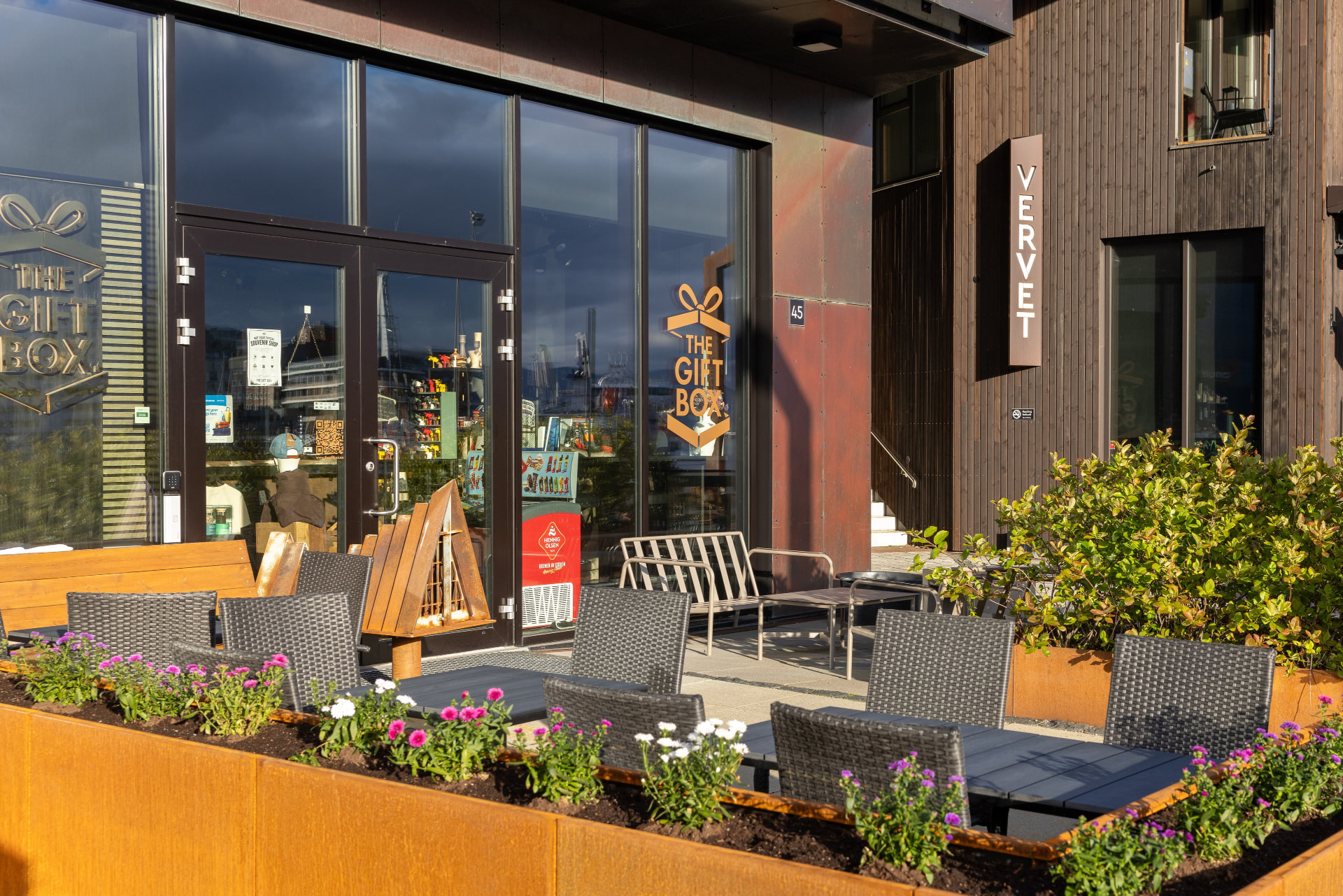The entrance to The Gift Box at Vervet in Tromsø with outdoor seating and flowers